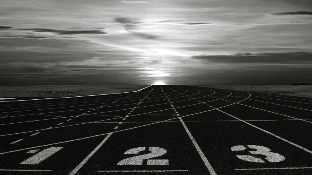 Empty running track with numbered lanes, charcoal tone