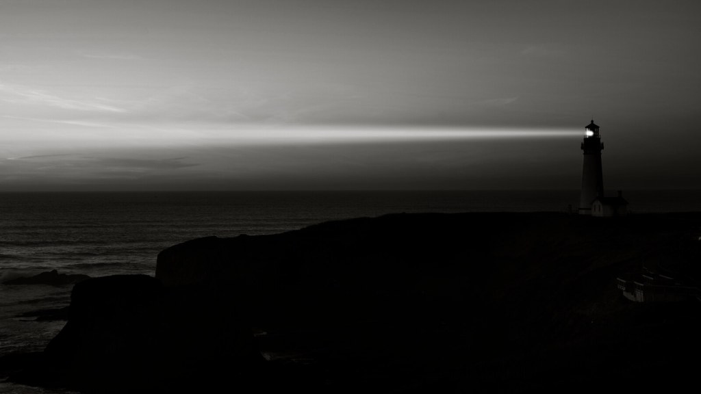 Lighthouse beam cutting through dusk